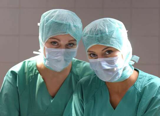 Zwei Krankenschwestern in gründer OP-Kleidung