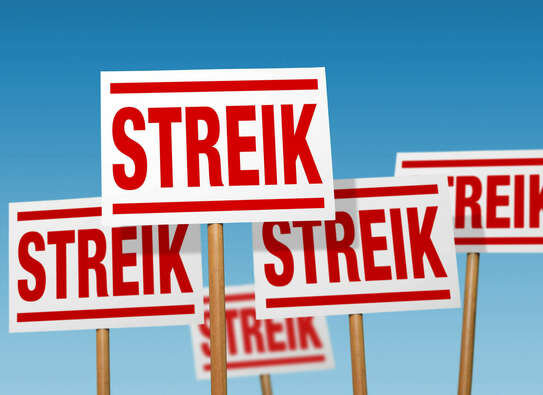 Mehrere Schilder mit dem Wort Streik in roter Schrift 