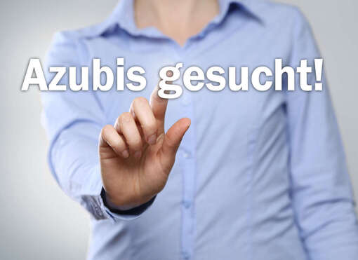 Azubis gesucht Person, die mit dem Finger auf den Text "Azubis gesucht" zeigt