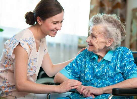 Adobe Stock Foto: Eine ältere Dame, die sich mit einer jungen Frau unterhält.