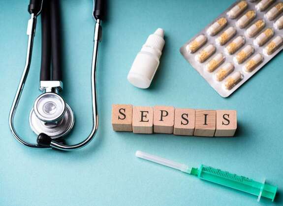 Würfel mit Schriftzug "Sepsis", Spritze, Tabletten, Tropfen und Stetoskop