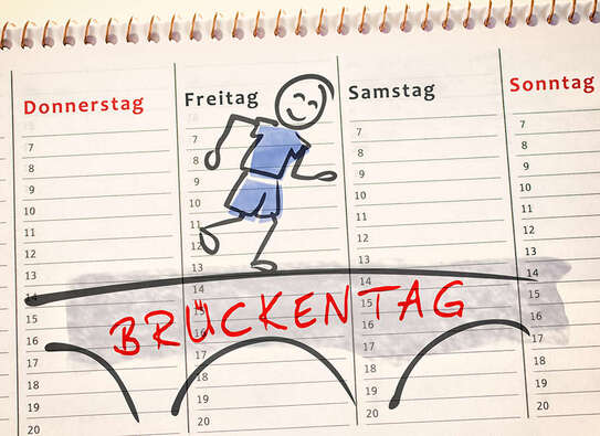 Kalender mit einem Cartoon-Männlein, das über den Schriftzug "Brückentag" läuft